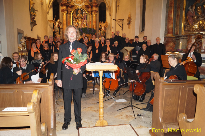 Adventskonzert 2017: geschafft!!! - Dirigent Bachmaier mit Blumenstrauß vor Chor und Orchester